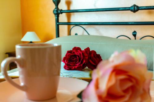 een kop koffie en een roos op een tafel bij La Casa del Nonno in Spoltore