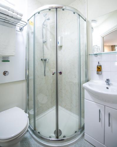 a bathroom with a shower and a toilet and a sink at Fox Connaught London ExCel in London