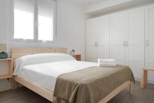 a bedroom with a large bed with white cabinets at BALENTZIAGA Getaria in Getaria