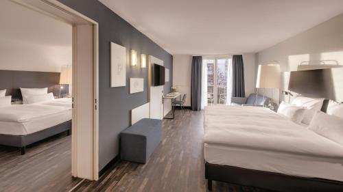 a hotel room with two beds and a mirror at Hotel the YARD Bad Honnef in Bad Honnef am Rhein