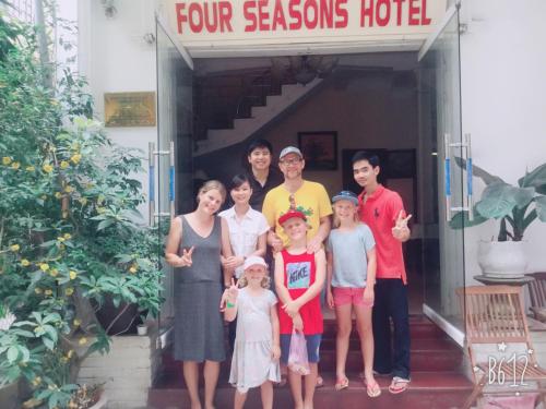 a family poses for a picture in front of a four seasons hotel at Hue Four Seasons Hotel in Hue