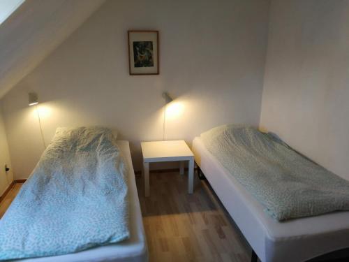 2 łóżka w małym pokoju ze stołem w obiekcie Slettegaard w mieście Slettestrand