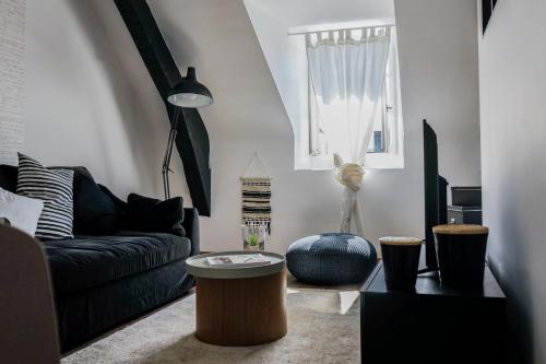 un salon avec un canapé et une table dans l'établissement La Cachette d Artistes - 1 Chambre, à Brive-la-Gaillarde