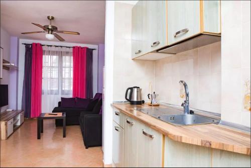 a kitchen with a sink and a living room at Los Cristianos Tenerife in Los Cristianos