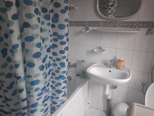 a bathroom with a sink and a shower curtain at Apartament z 3 sypialniami na wyłączny użytek - Selekcyjna 15 in Łódź