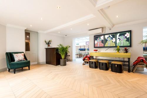 a living room with a fireplace and a green chair at Burnside Hotel in Stratford-upon-Avon