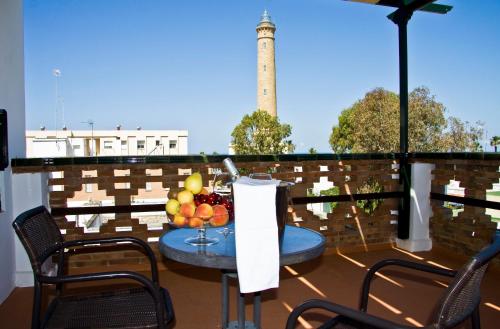 a balcony with a table and chairs and a lighthouse at Hostal El Faro in Chipiona