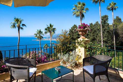 a balcony with palm trees and a view of the ocean at Hotel Villa Belvedere in Taormina