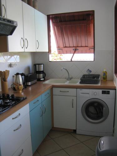 a kitchen with a washing machine and a window at GÏTE REVE CARAIBES " LA PERLE " in Bouillante