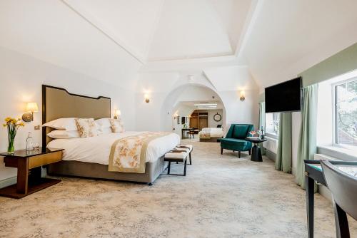 a bedroom with a large bed and a living room at Burnside Hotel in Stratford-upon-Avon