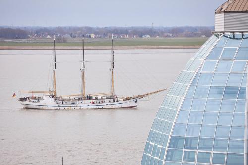 a boat on the water next to a building at Weserdeichblick in Bremerhaven