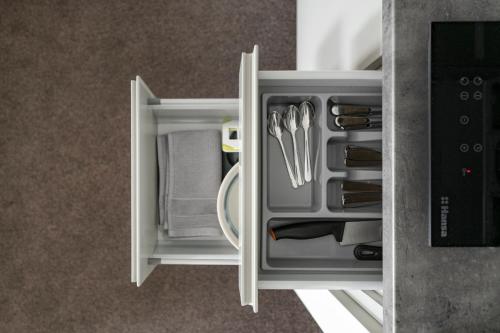 an open drawer with utensils in a refrigerator at Senamiesčio apartamentai in Tauragė