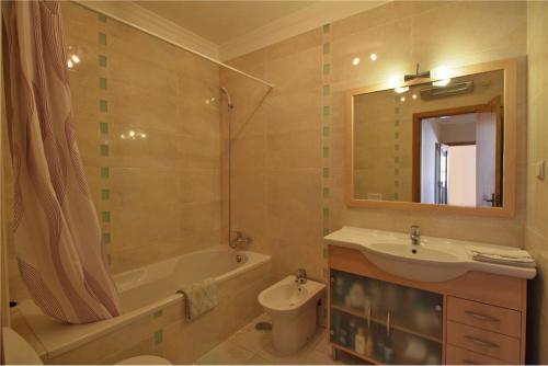 a bathroom with a sink and a tub and a toilet at Bel appartement centre de Tavira in Tavira