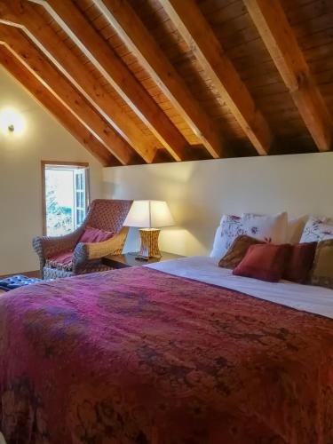 a bedroom with a large bed and two chairs at Casa de Quintã in Marco de Canaveses