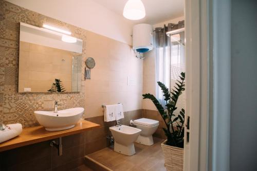 a bathroom with a sink and a toilet and a mirror at The Lighthouse in Trappeto