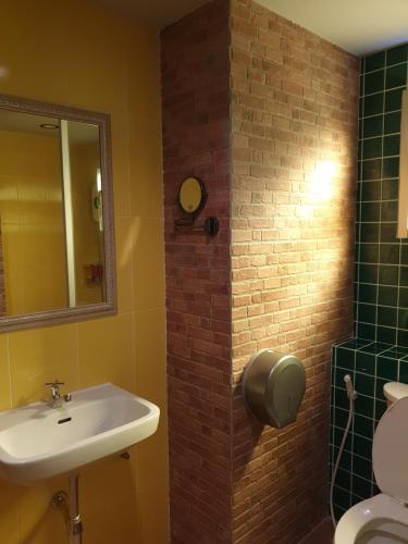 a bathroom with a toilet, sink, and mirror at Baan Baimai Boutique Room in Phra Nakhon Si Ayutthaya