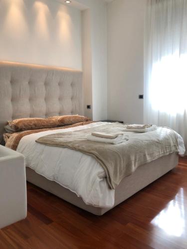 a bedroom with a large bed with a white headboard at Maggiore Cozy Apartment in Milan