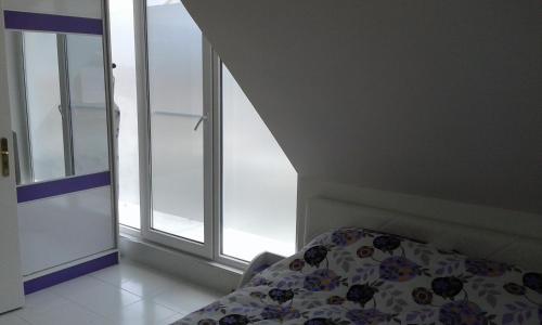 a bedroom with a bed next to a window at Apartment Sagittarius in Kyustendil