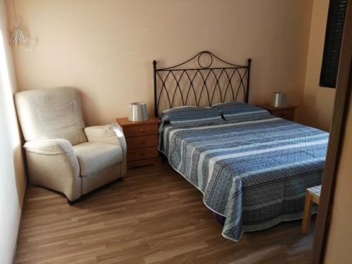 een slaapkamer met een bed en een stoel bij Donde Brilla el Sol in Candelaria