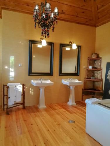 a bathroom with two sinks and a chandelier at Casa de Quintã in Marco de Canaveses