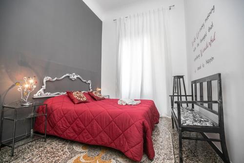 1 dormitorio con 1 cama roja y 1 silla en Homes in Genoa - Gold and Silver, en Génova