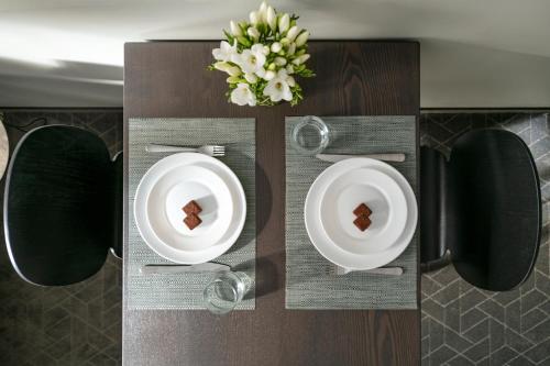 a table with two plates and a cake on it at Senamiesčio apartamentai in Tauragė