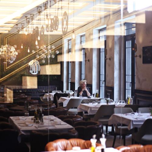 a woman sitting at a table in a restaurant at Industrial 1853. in Kragujevac