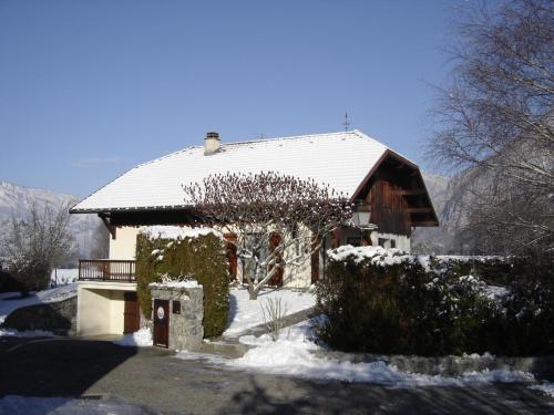 una casa con techo cubierto de nieve en La Biolette, en Faverges