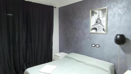 1 dormitorio con 1 cama y una foto de la torre Eiffel en Richbaby en Roma