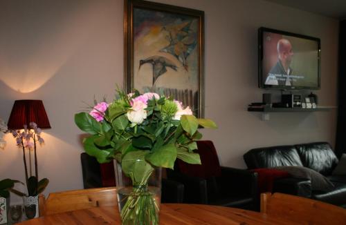 a vase of flowers sitting on top of a table at Appartement met zeezicht max 6 p in Ostend