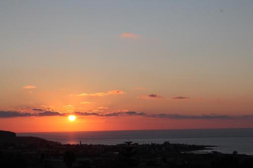 a sunset over the ocean with the sun in the sky at Casale Belvedere vista mare in Valderice