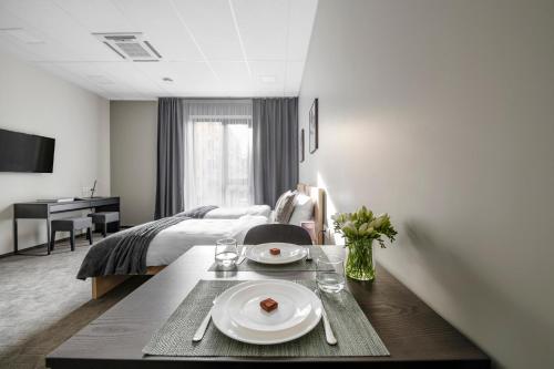 a hotel room with a table and a bed at Senamiesčio apartamentai in Tauragė