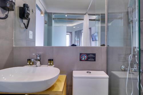 a bathroom with a sink and a toilet and a mirror at athensotel in Athens