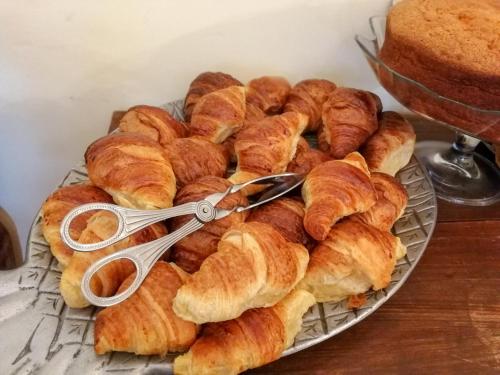 een bosje croissants op een bord met een tang bij Casa de Quintã in Marco de Canavezes