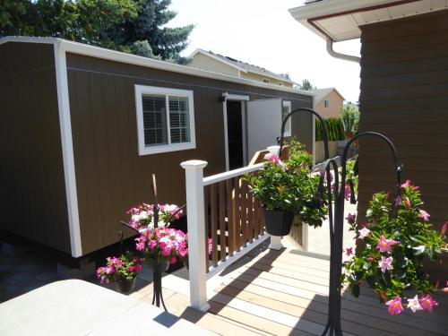 a backyard deck with flowers and a house at Sweet tiny house in Kent