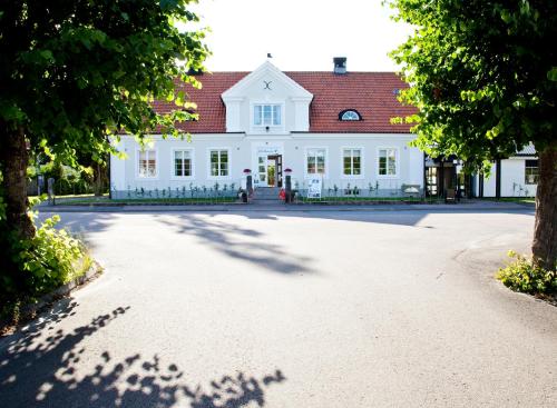 a large white building with a red roof at Ekebacken Hotell & Konferens in Markaryd