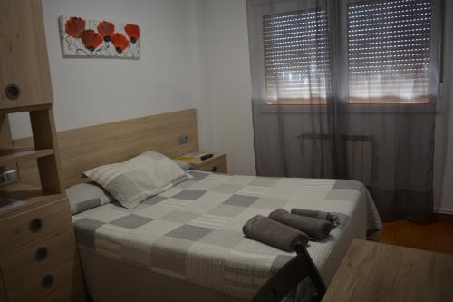 a bedroom with a bed with two towels on it at Hospedaje Jose Rey in Santiago de Compostela
