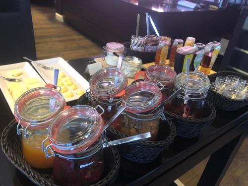 a table with jars of jam and baskets of food at König`s Hotel am Schlosspark in Rheda-Wiedenbrück