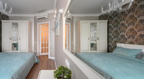 a bedroom with two beds and a chandelier at Arkadia Plaza Design Apartment in Odesa