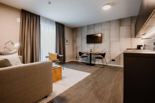 a living room with a couch and a table at Timehouse Serviced Apartments in Munich