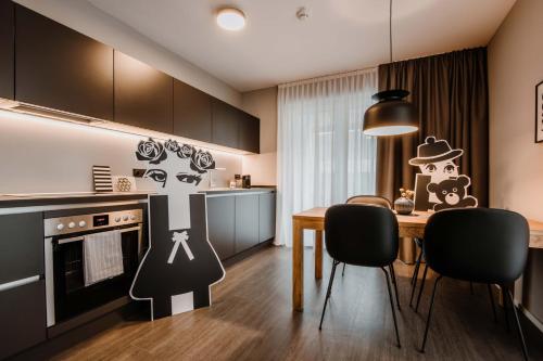 a kitchen with a table and chairs in a room at Timehouse Serviced Apartments in Munich