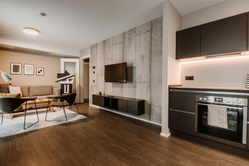 a living room with a kitchen and a couch at Timehouse Serviced Apartments in Munich