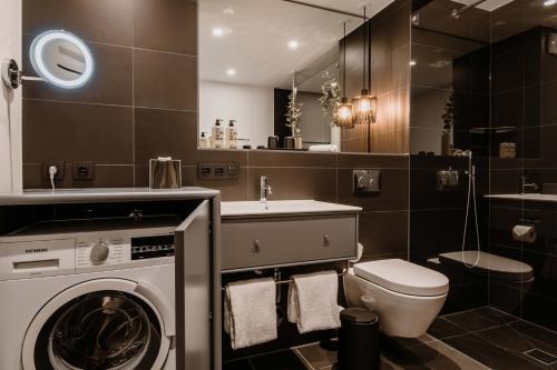 a bathroom with a washing machine and a toilet at Timehouse Serviced Apartments in Munich