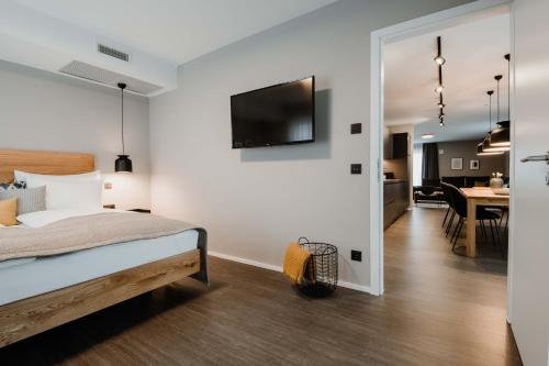 a bedroom with a bed and a tv on a wall at Timehouse Serviced Apartments in Munich