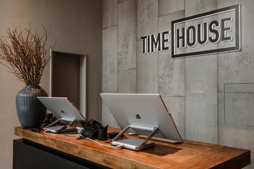 two laptops sitting on a desk with a vase at Timehouse Serviced Apartments in Munich