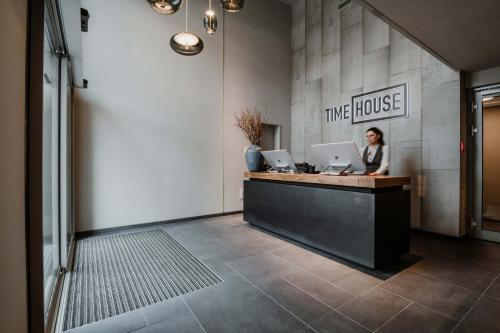 a woman sitting at a counter with two computers at Timehouse Serviced Apartments in Munich
