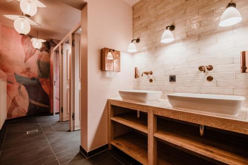 two sinks in a bathroom with two mirrors at Timehouse Serviced Apartments in Munich