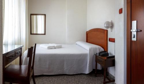 a bedroom with a bed with two towels on it at San Miguel in Ponferrada