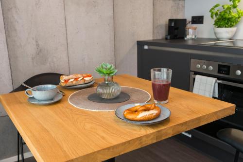a wooden table with two plates of food on it at Timehouse Serviced Apartments in Munich