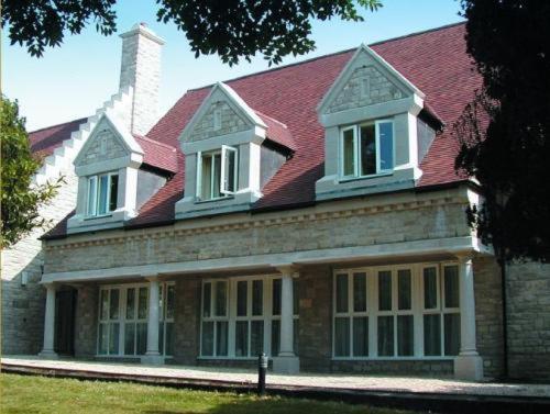 a large brick house with a red roof at Louisa Lodge & Purbeck House Hotel in Swanage